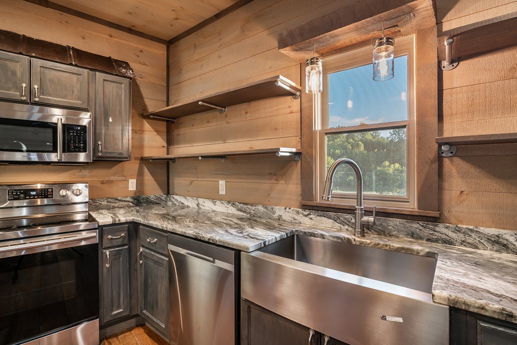 2637 River Road Mineral Bluff, GA 30559 - Photo 42 of 67 a kitchen with stainless steel appliances granite countertop a sink a stove and a microwave oven