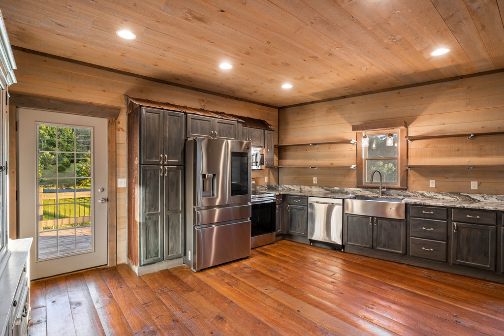 2637 River Road Mineral Bluff, GA 30559 - Photo 43 of 67 a kitchen with stainless steel appliances granite countertop a refrigerator a sink dishwasher a stove and a large countertops with wooden floor