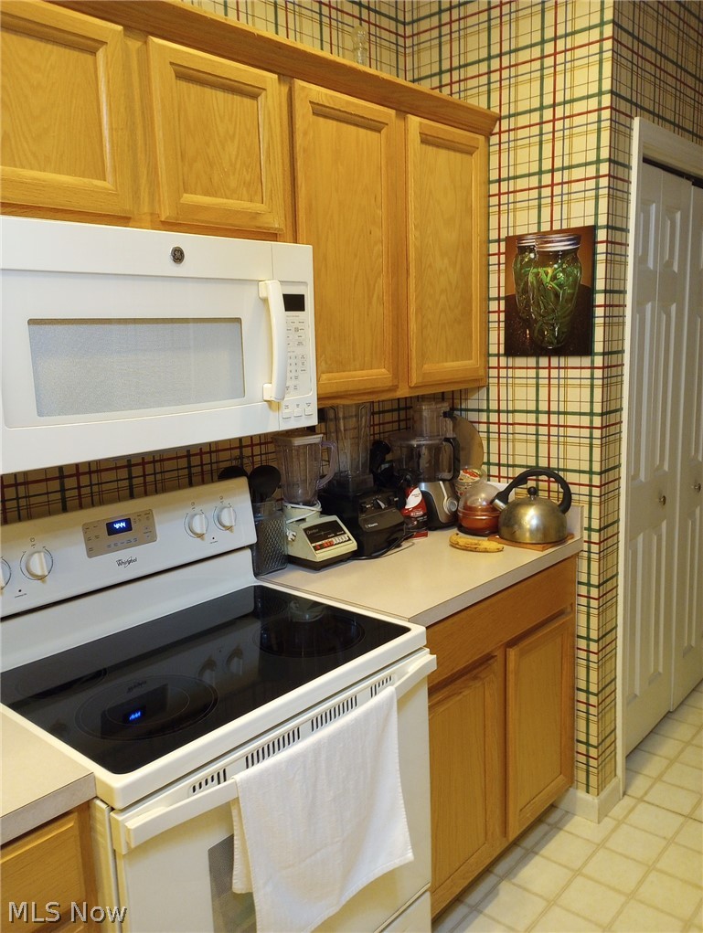 304 Wilcox Road Youngstown, OH 44515 - Photo 10 of 35 Kitchen featuring light tile patterned flooring, tasteful backsplash, and white appliances