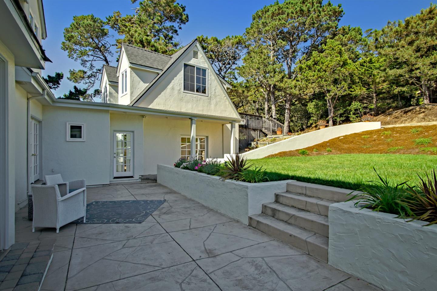 21 Mentone Road Carmel, CA 93923 - Photo 63 of 80 a view of a white house with a yard and plants