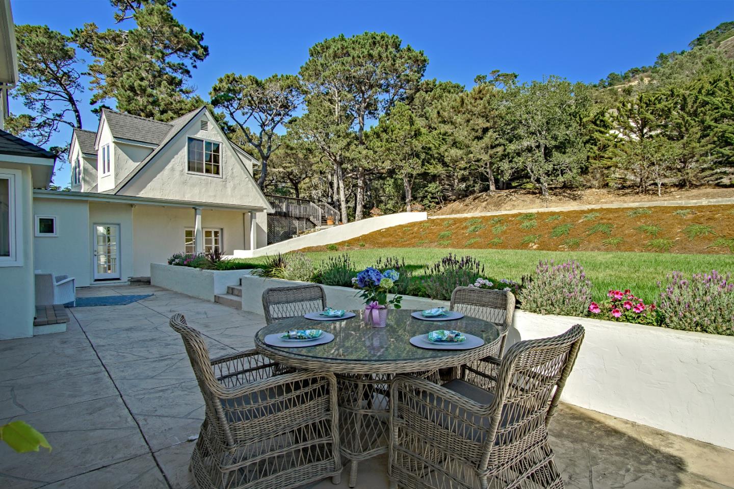 21 Mentone Road Carmel, CA 93923 - Photo 64 of 80 a patio with a table and chairs and potted plants