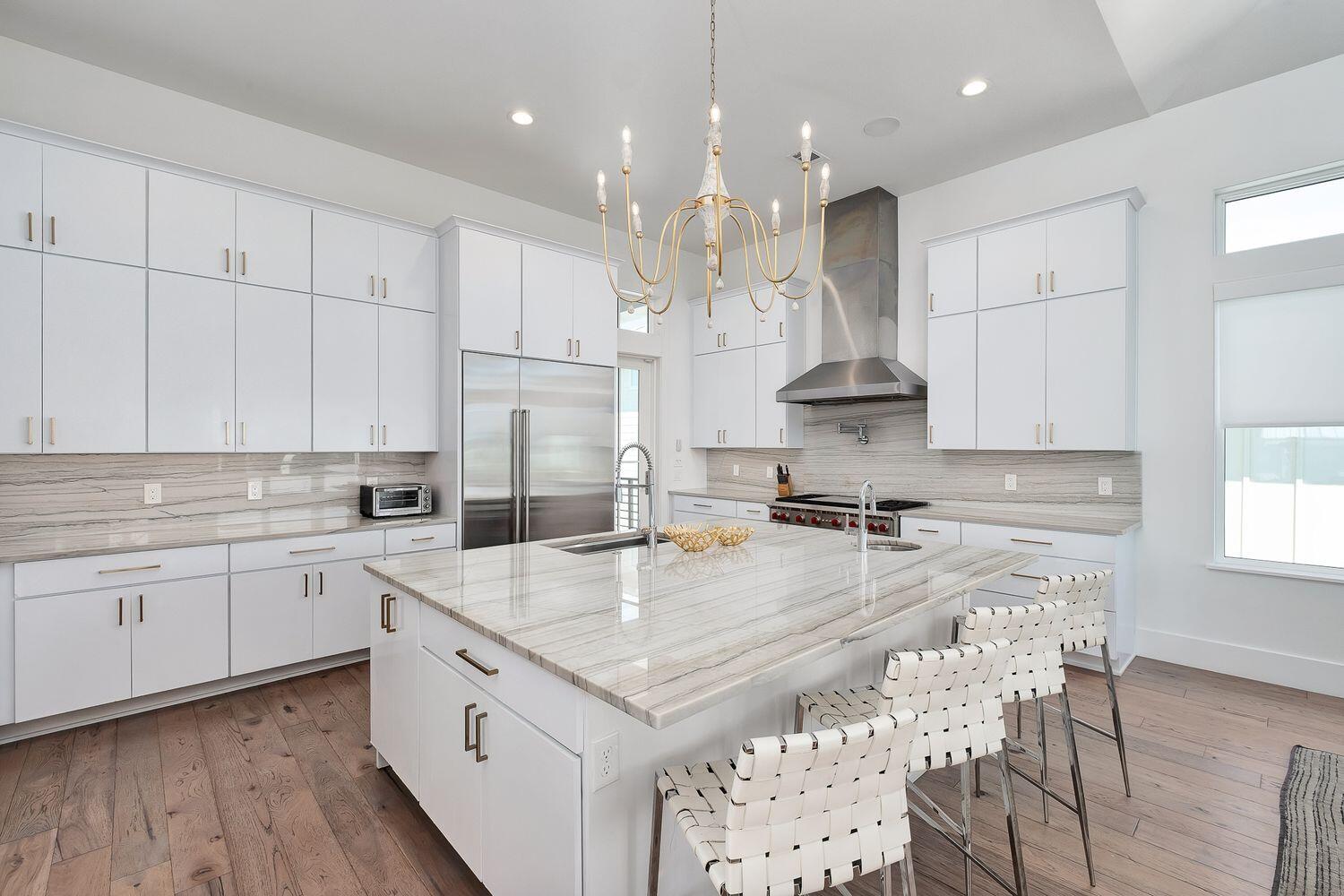 2657 East County Highway 30A Santa Rosa Beach, FL 32459 - Photo 11 of 59 a large kitchen with kitchen island a stove a sink a center island and wooden floor