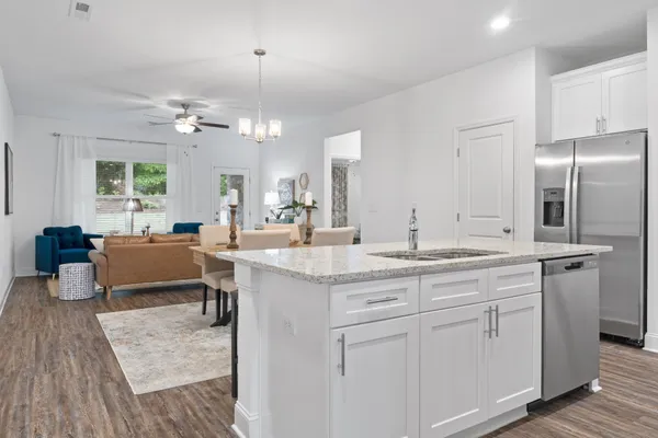 a kitchen with kitchen island granite countertop a sink cabinets and stainless steel appliances