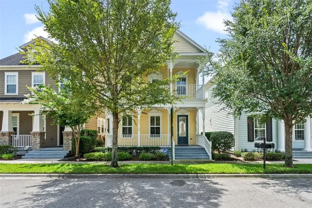 a front view of a house with garden and trees