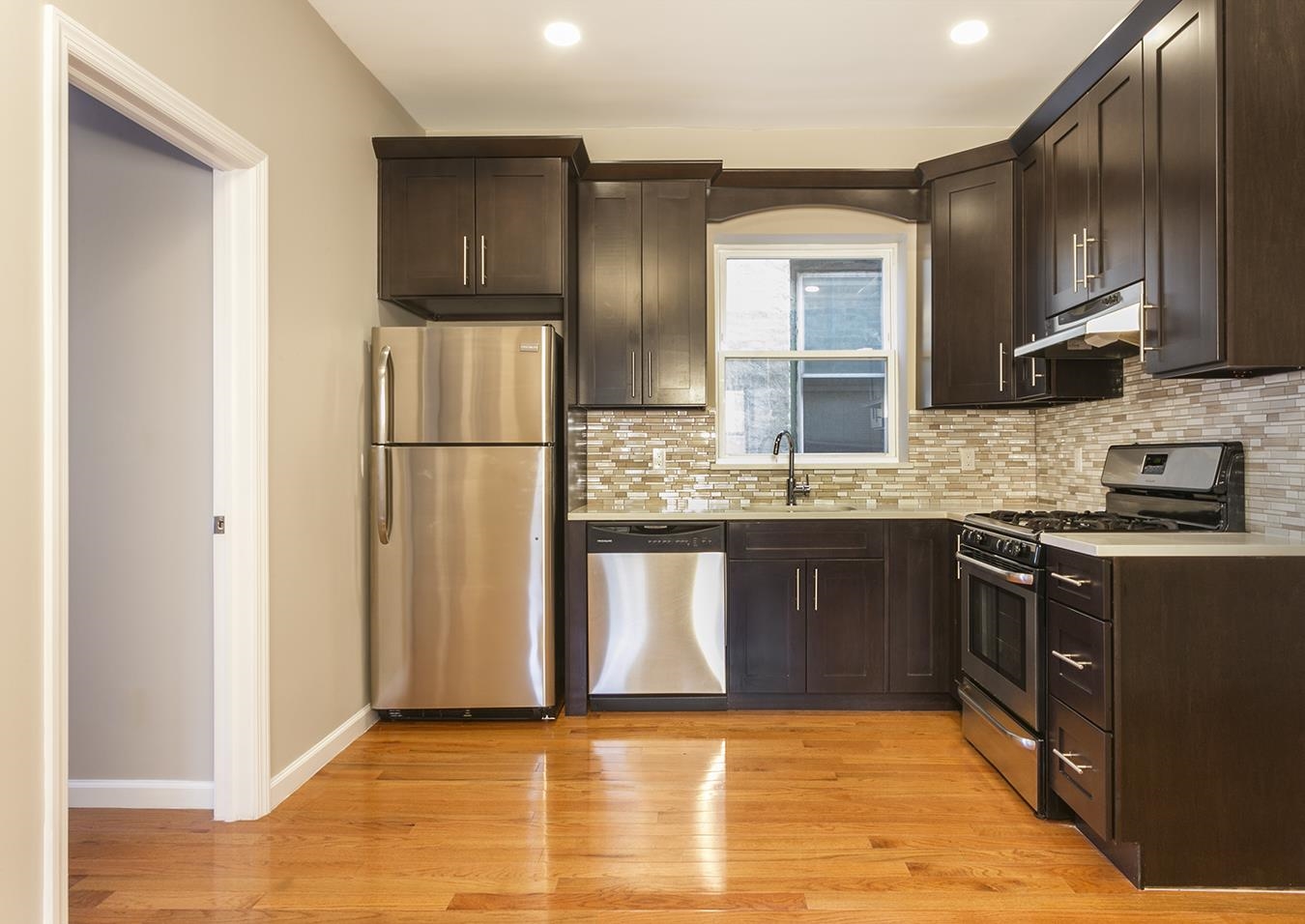 a kitchen with stainless steel appliances granite countertop a refrigerator a stove top oven a sink and dishwasher