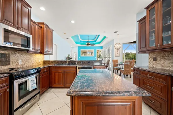a kitchen with stainless steel appliances granite countertop a stove top oven a refrigerator and a cabinets