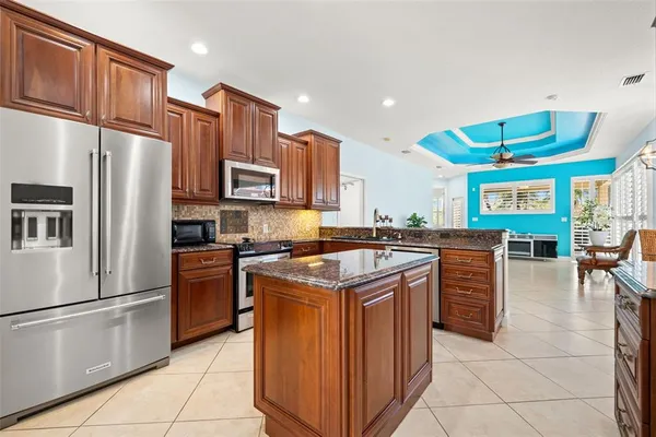 a kitchen with kitchen island granite countertop wooden cabinets and a stove top oven