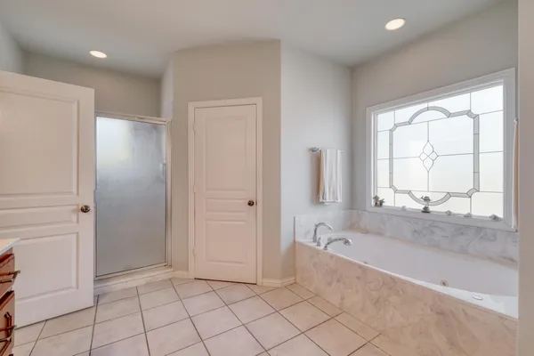 a spacious bathroom with a bathtub and a shower