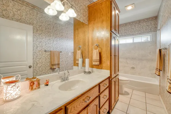 a bathroom with a tub sink and mirror