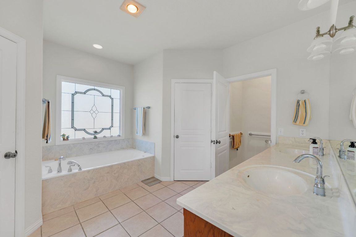 1949 Farm To Market Road 619 Elgin, TX 78621 - Photo 17 of 36 Bathroom featuring double vanity, a bath, light tile patterned floors, and recessed lighting