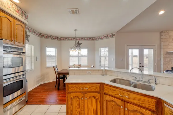 a kitchen with stainless steel appliances granite countertop a sink stove and refrigerator