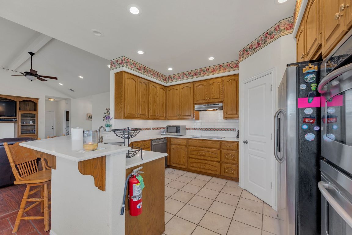 1949 Farm To Market Road 619 Elgin, TX 78621 - Photo 35 of 36 a kitchen with stainless steel appliances granite countertop a sink stove and refrigerator