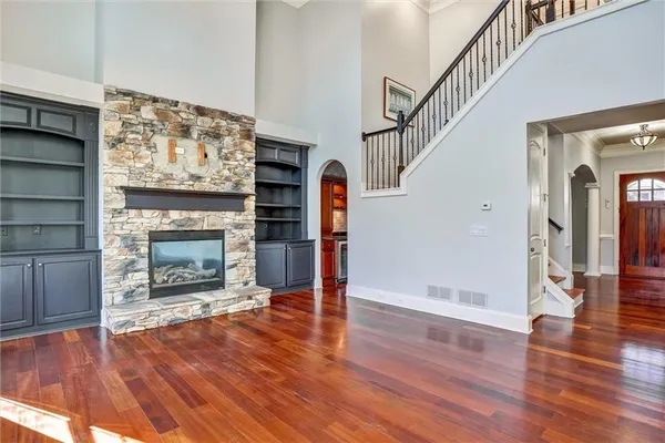 a view of empty room with wooden floor and fireplace