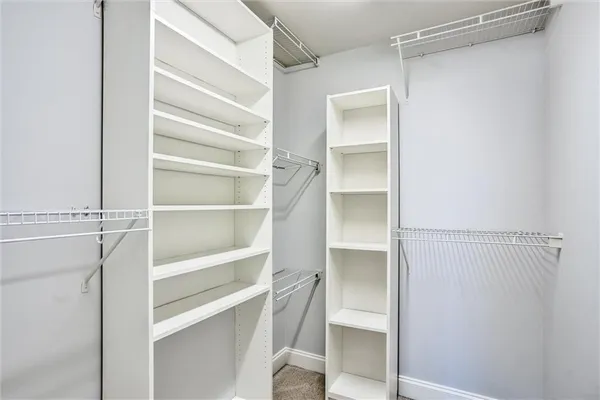 a view of walk in closet with empty racks