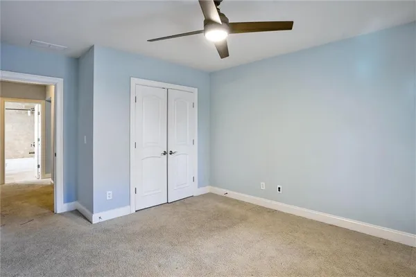 an empty room with closet and windows