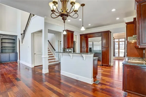 a view of entryway and kitchen with wooden floor