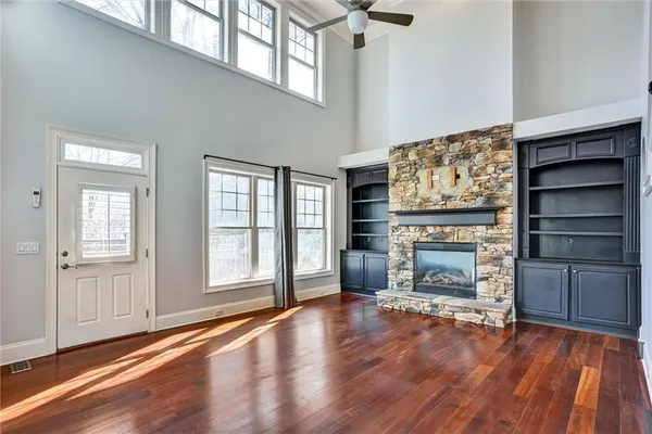 wooden floor fireplace and windows in an empty room