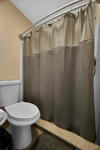 a white toilet sitting next to a shower