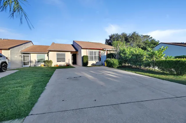 a front view of a house with a yard and trees
