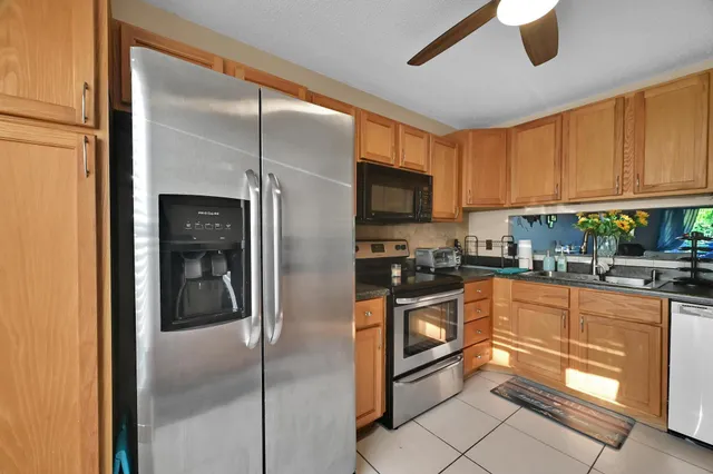 a kitchen with granite countertop a refrigerator and a sink