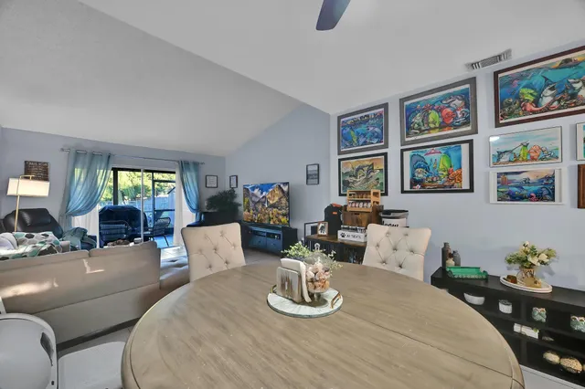 a living room with furniture two window and a painting on the wall