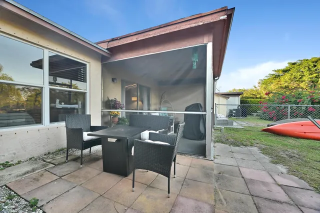 a view of a patio with table and chairs and potted plants