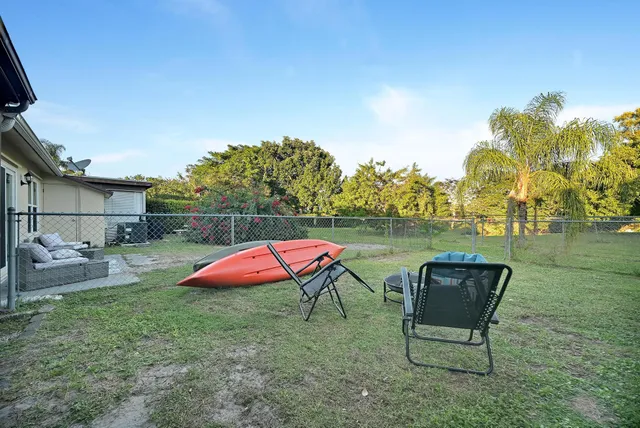 a view of a backyard with table and chairs under an umbrella