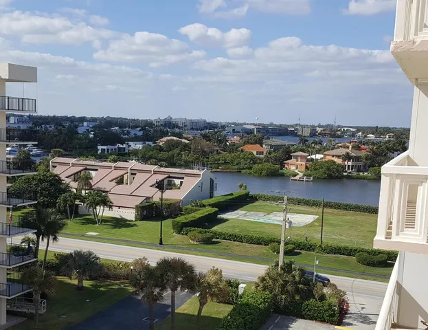 an aerial view of a city with lots of residential buildings ocean and mountain view in back