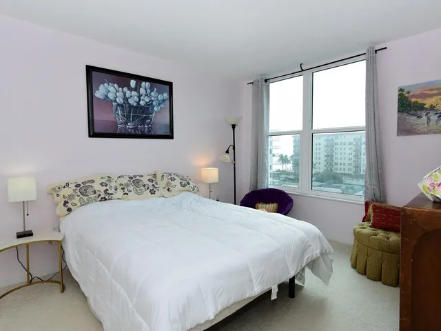 a bedroom with bed and wall painting