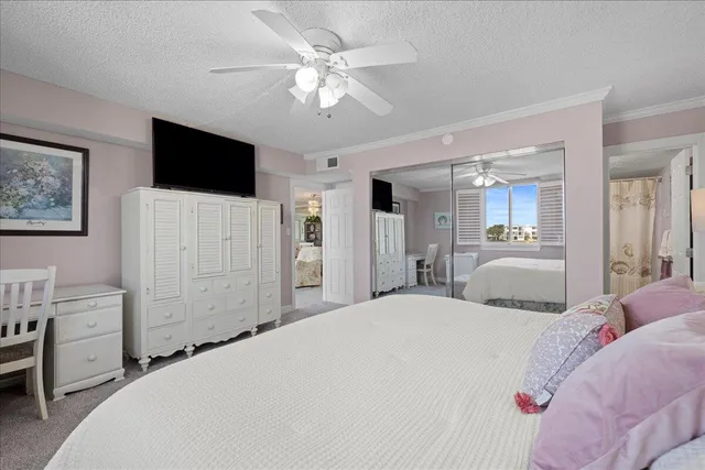 a bedroom with a bed a chandelier and a flat screen tv
