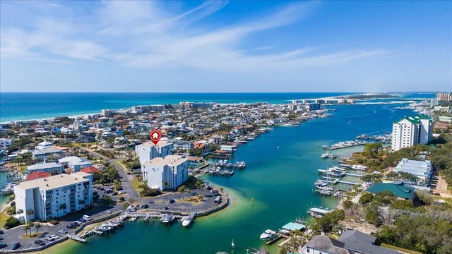 an aerial view of a city with lots of residential buildings ocean and mountain view in back