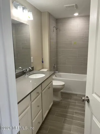 a bathroom with a double vanity sink toilet mirror and bathtub