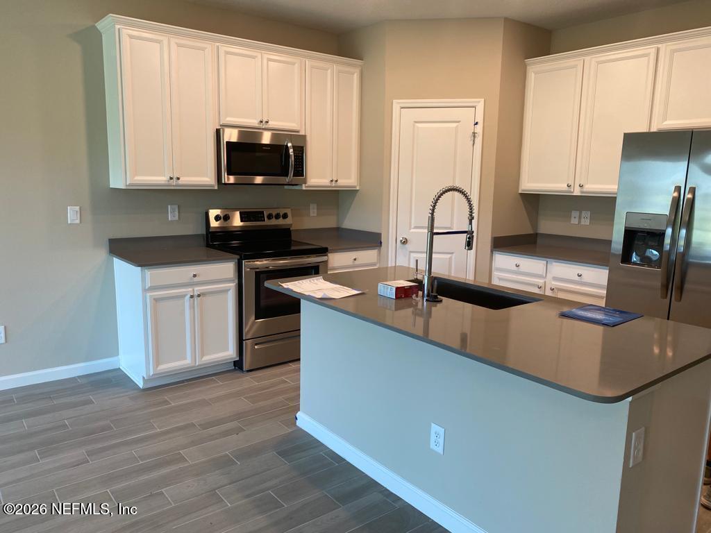 243 Boracay Circle St. Johns, FL 32259 - Photo 8 of 20 a kitchen with stainless steel appliances granite countertop a stove a sink and a microwave