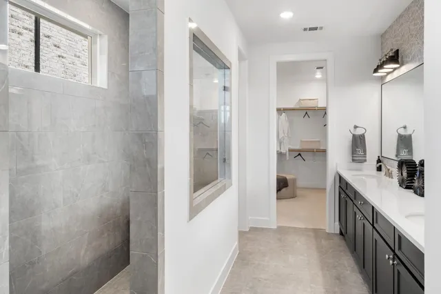a bathroom with a double vanity sink a mirror and a shower