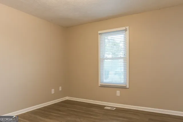a view of a small space with wooden floor and a window