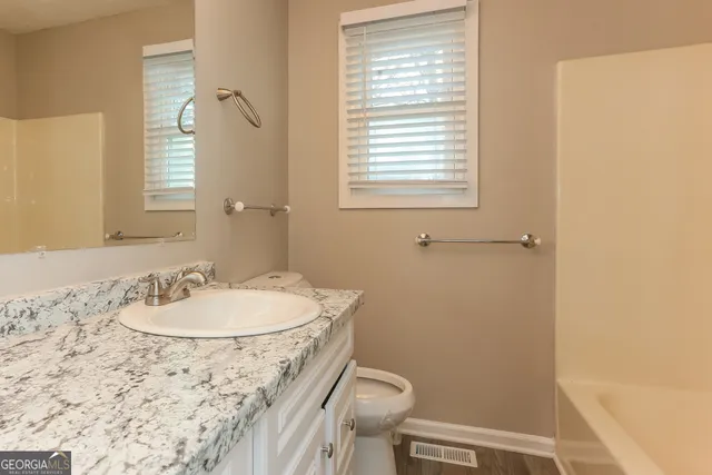 a bathroom with a sink toilet and a mirror