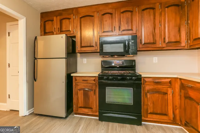 a kitchen with stainless steel appliances granite countertop a refrigerator stove and microwave