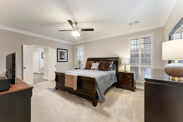 a spacious bedroom with a bed flat screen tv and window