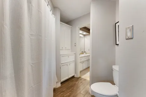 a bathroom with a granite countertop toilet and a sink