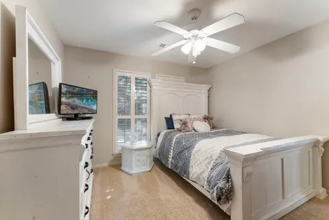 a bedroom with a large bed and a flat tv screen on dresser