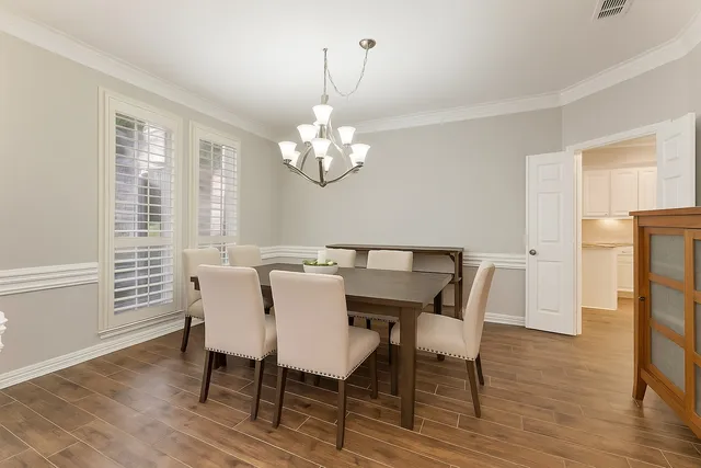 a view of a dining room with furniture a chandelier and wooden floor