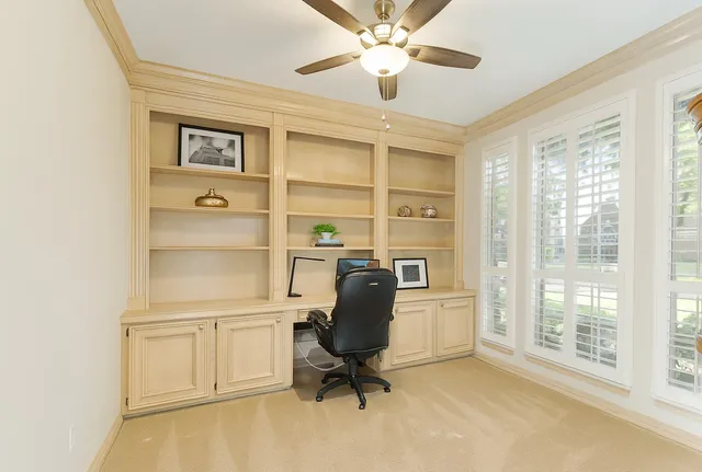 a view of a workspace with furniture and a window