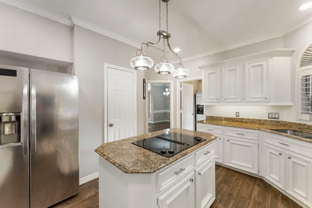 a kitchen with stainless steel appliances granite countertop a sink refrigerator and cabinets