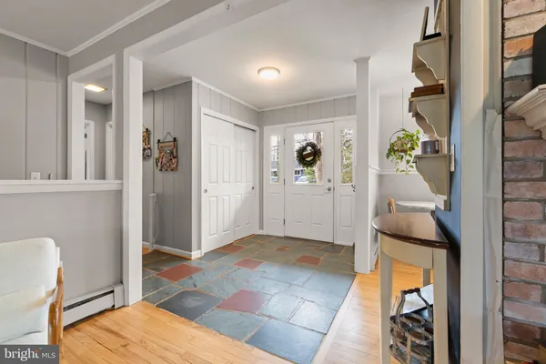 a kitchen with a refrigerator a sink dishwasher a stove and a dining table with wooden floor