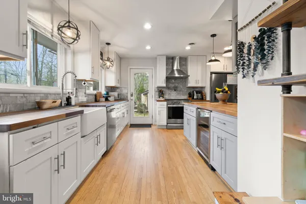 a kitchen with stainless steel appliances granite countertop a stove and cabinets