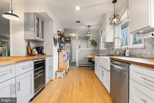 a kitchen that has a lot of cabinets a sink and a wooden floor