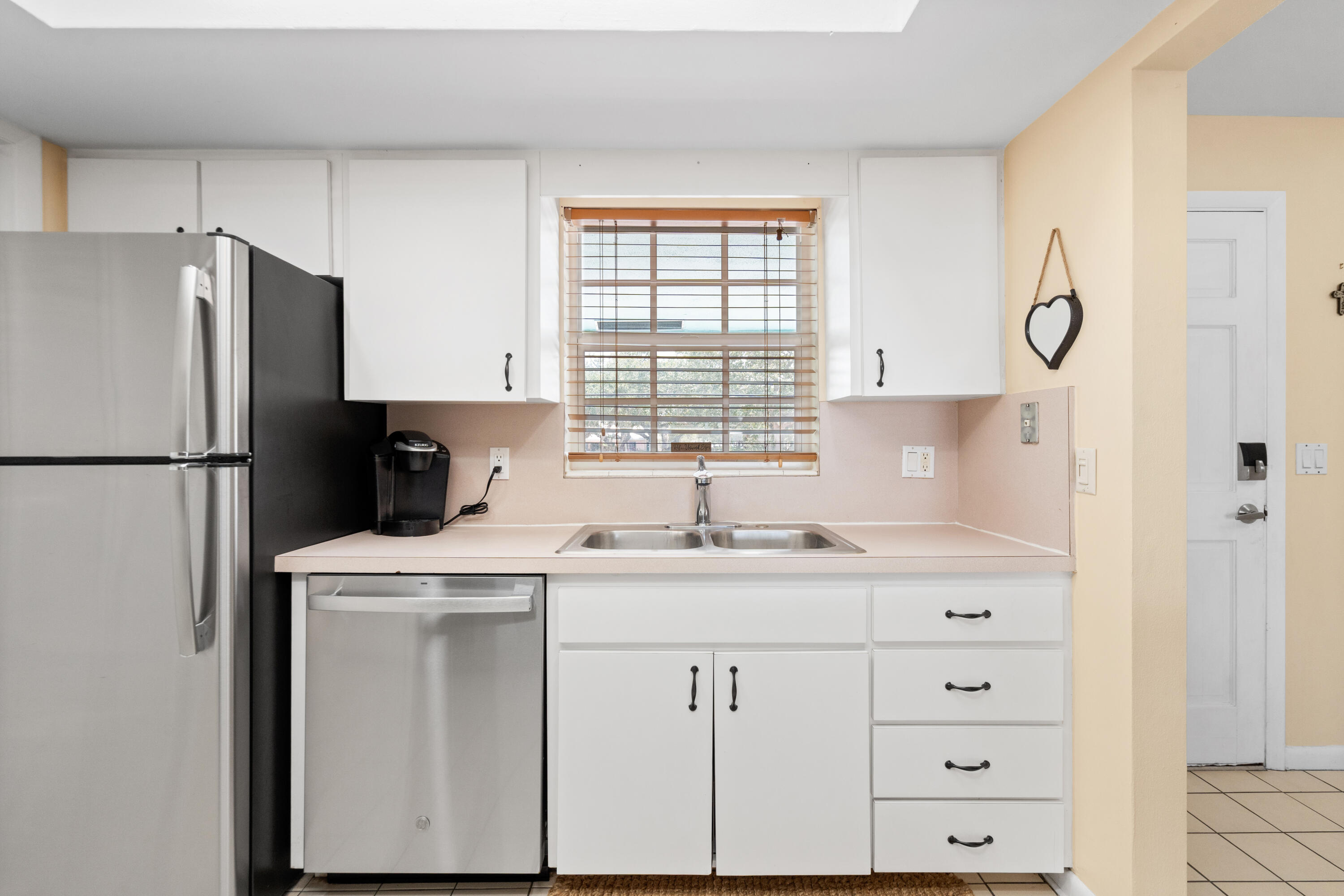 249 Center Street, Unit 2C Jupiter, FL 33458 - Photo 14 of 29 a kitchen with a refrigerator a sink and a window