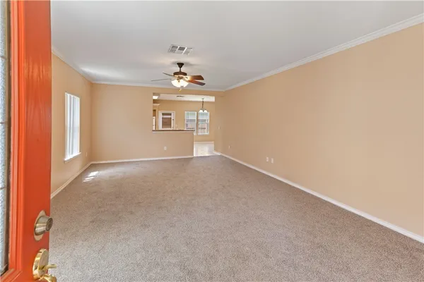 en empty room with windows and chandelier
