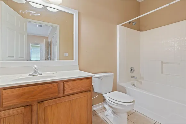 a bathroom with a granite countertop sink mirror vanity and toilet