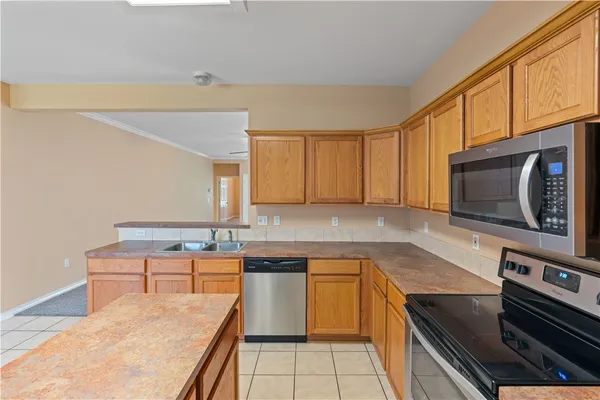 a kitchen with stainless steel appliances a stove microwave and sink